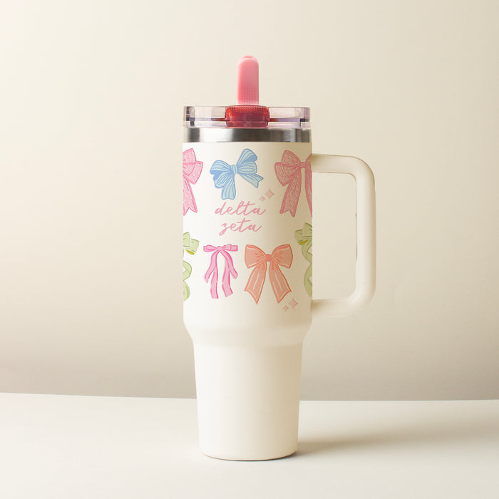The Darling Effect's Delta Zeta 40 oz Lifestyle Flip Straw Tumbler Bow Affair features a handle, clear lid, pink script, and colorful bows—a stylish, leak-resistant choice for everyday use.
