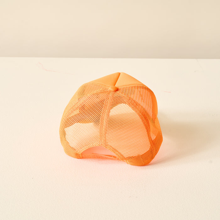 The Darling Effect's Orange Game Day Trucker Hat, perfect for showing team spirit, is pictured upside down on a white surface with a simple light background.