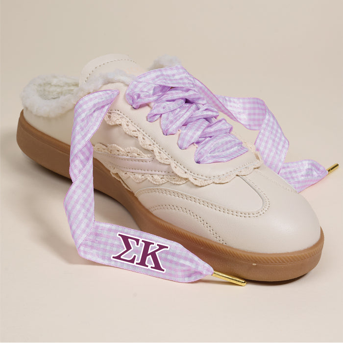 The Darling Effect's Sigma Kappa Step It Up Shoelaces feature light purple gingham with gold tips and the ฮฃฮ symbol, shown here on a cream sneaker with fluffy interior and beige lace trimโideal for sorority gifts against a neutral backdrop.