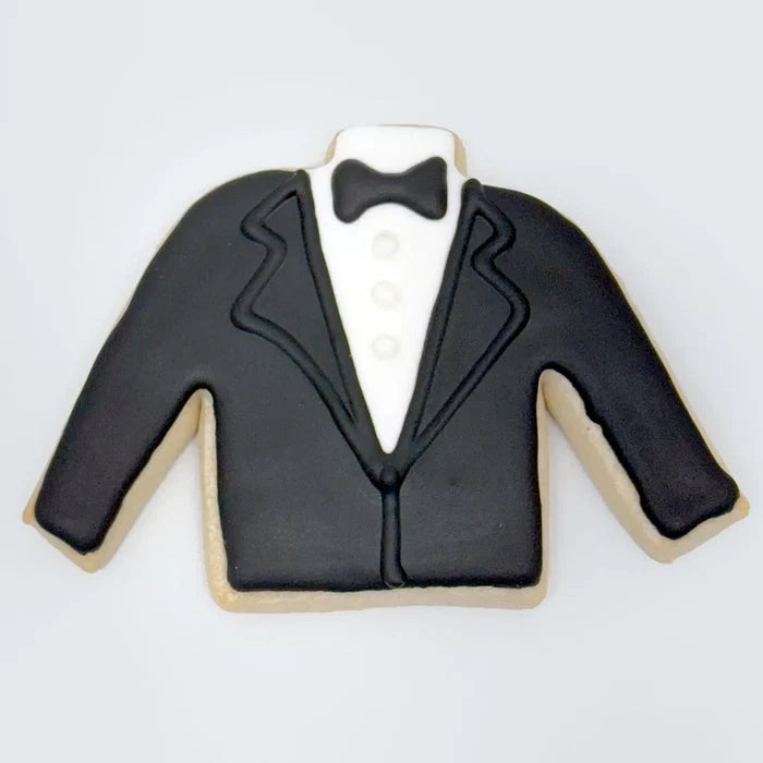 Tuxedo jacket-shaped cookie decorated with black icing for the suit, white icing for the shirt and buttons, and a black bow tie at the top