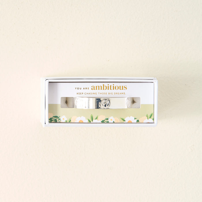 The Darling Effect's You Are Ambitious Cuff Bracelet, a sterling silver piece with a floral design and uplifting message on the box, is set against a simple backgroundβan inspiring and meaningful gift.
