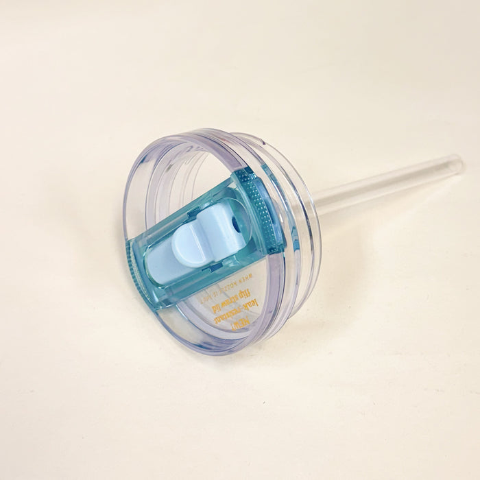 A close-up of The Darling Effect 20 oz Blue Lifestyle Flip Straw Replacement Lid features a blue flip-top, attached clear straw, and leak-resistant seal, set against a plain white background.