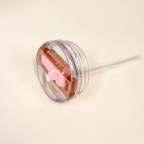 The Darling Effect’s 20 oz Light Pink Lifestyle Flip Straw Replacement Lid features a leak-resistant seal, integrated straw, and pink bow decoration, shown on a plain white surface.