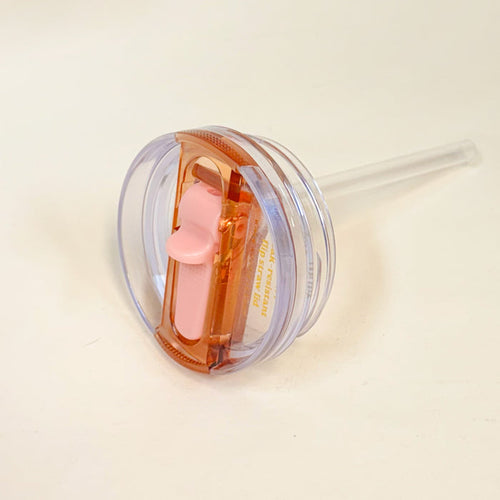 The Darling Effect’s 20 oz Peach Lifestyle Flip Straw Replacement Lid features a clear design with a pink and orange sliding closure and attached straw, perfect for replacing your tumbler lid. Pictured here on a white surface.