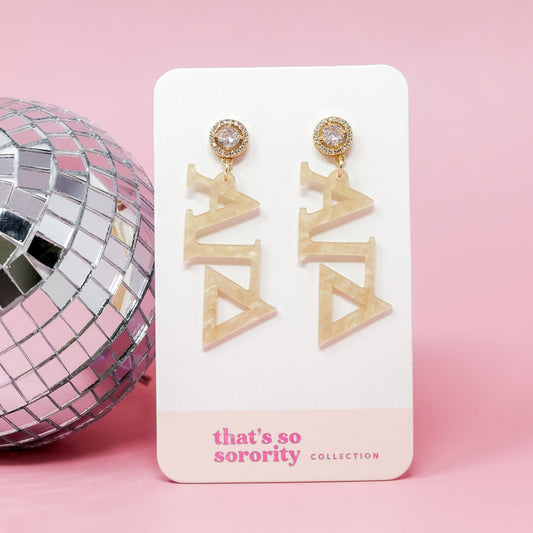 Alpha Gamma Delta Letter Gold Acrylic Earrings by The Darling Effect, shown on a branded card against a pink background with a silver disco ball—perfect for sisterhood events or as a fun addition to any bid day basket.