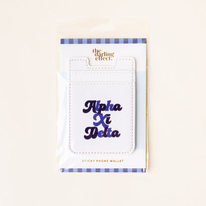 The Alpha Xi Delta Stick-On Phone Wallet by The Darling Effect features navy blue cursive lettering, a blue and white striped border, and comes in packaging—making it an ideal sorority gift.