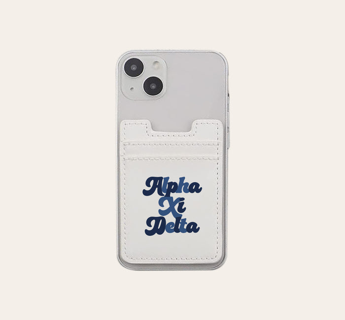 The Darling Effect Alpha Xi Delta Stick-On Phone Wallet in white attaches to a clear smartphone case and features bold dark blue script—an ideal sorority gift.