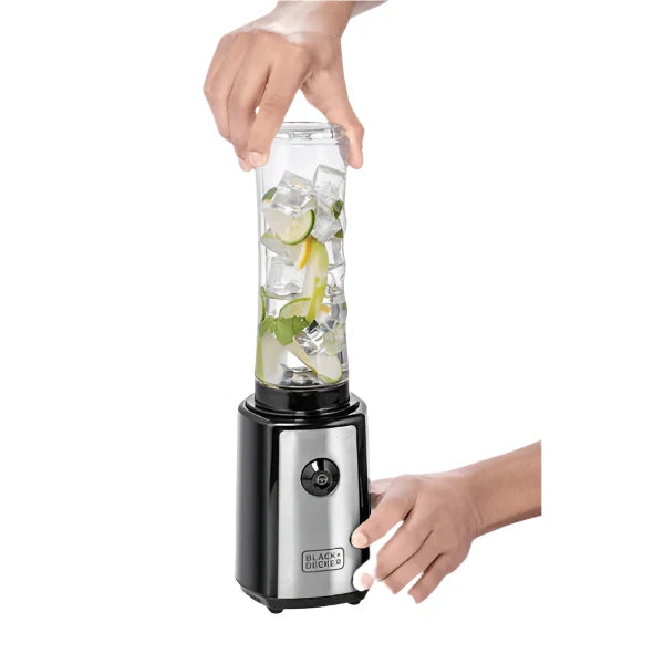 Hand holding a portable blender with ingredients inside on a white background