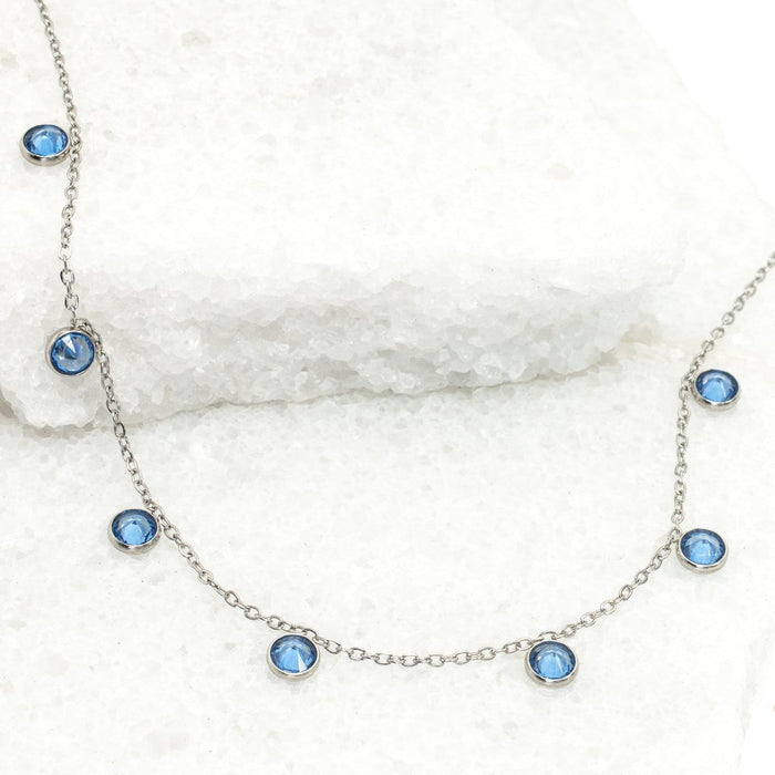 Necklace with blue gemstones on a white marble surface