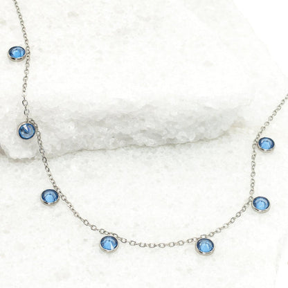 Necklace with blue gemstones on a white marble surface