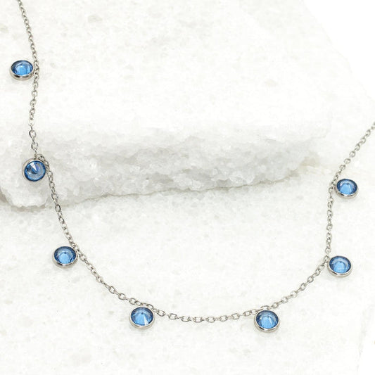 Necklace with blue gemstones on a white marble surface