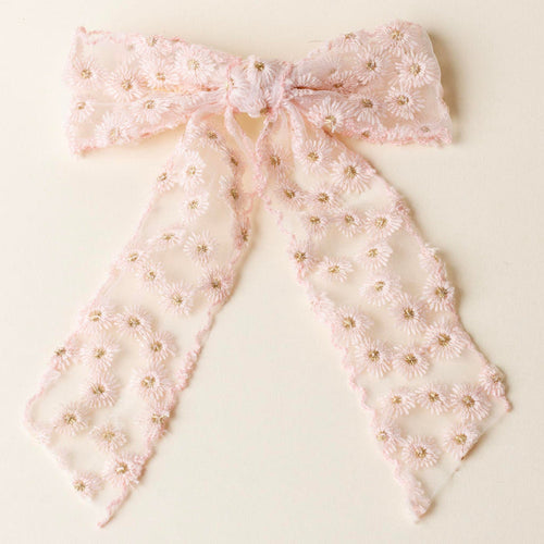 The Blush Ditzy Daisies Hair Bow by the-darling-effect, featuring delicate pink daisies with gold bead centers and embroidered flowers, is displayed flat on a cream background.