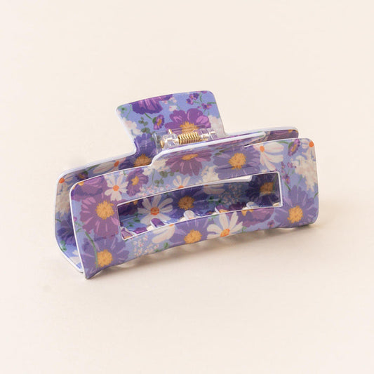 The-darling-effect's Bouquet Beauty Purple Claw Clip is a rectangular accessory with a purple base and floral print in white, yellow, and purple on an off-white background—stylish and strong-holding for your hair.
