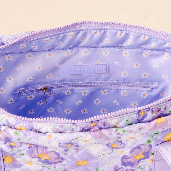 The Everyday Quilted Tote Bag by the-darling-effect features a bouquet-inspired lavender design with a lilac interior, white daisy lining, zippered pocket, and signature label—perfect as your daily carry-all.