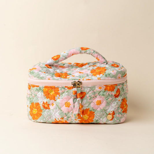 The-darling-effect's Bouquet Beauty Sage Glam & Go Quilted Cosmetic Bag features a handle, zipper closure, gold charm tag, and a floral pattern with orange and yellow flowers and green leaves on a light pastel background.