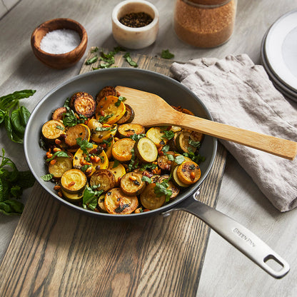 Vegetables with herbs cooking in Chatham ceramic nonstick cookware set on a kitchen counter.