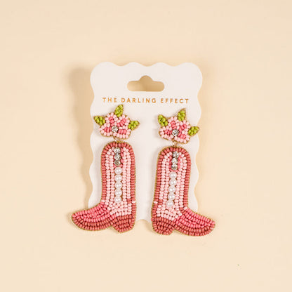 The Darling Effect Cowgirl Boot Beaded Earrings feature pink hand-beading, pearls, rhinestones, and floral details—perfect for adding a playful touch to your jewelry collection.