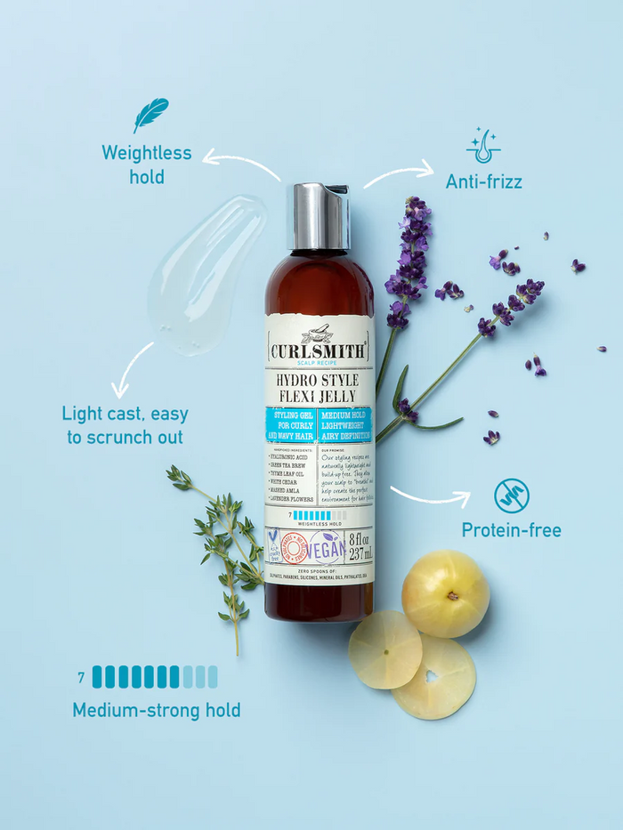 Curlsmith hair product bottle with lavender and apple slices on a light blue background