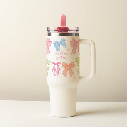 The Darling Effect's Delta Zeta 40 oz Lifestyle Flip Straw Tumbler Bow Affair features a handle, clear lid, pink script, and colorful bows—a stylish, leak-resistant choice for everyday use.