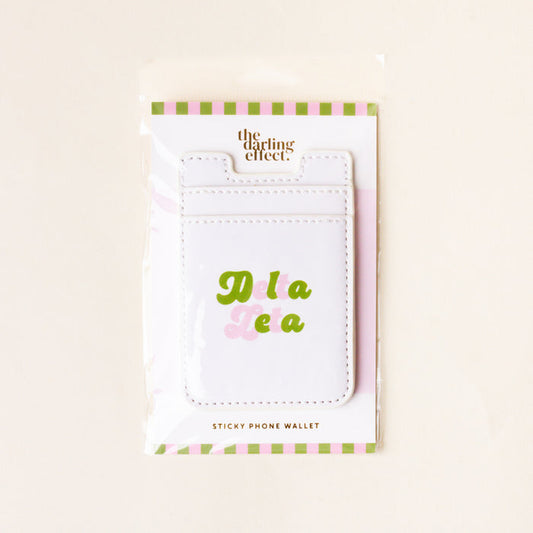 The Delta Zeta Stick-On Phone Wallet by The Darling Effect features white material with Delta Zeta in green and pink, packaged in a clear bag with light green and pink stripes—perfect as a cute sorority gift.