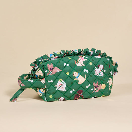 The Darling Effect’s Dog Days Essentials Quilted Cosmetic Pouch features playful cats, dogs, bones, and balls on green fabric with a ruffled edge. It has a handle and zipper—ideal for organizing your essentials on the go.