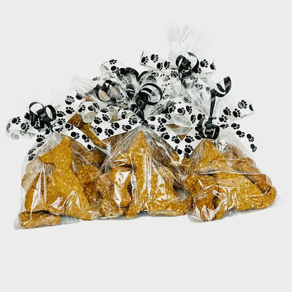 Meeko's dog and bow Treats, packaged in a cellophane bag and tied with ribbons.