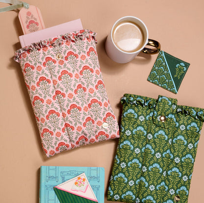 The Everbloom Dusty Rose Book Cover with a floral pattern lies on a beige surface beside coffee, a notebook, pink paper, and envelopes—ideal as a cute book cover or for protecting your books.