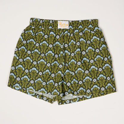 Everbloom Forest Green All Day Boxer Shorts by The Darling Effect feature an elastic waistband, breathable fabric, and a green and blue floral fan pattern on a dark background. An inside label displays the brand name.