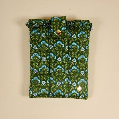 The Darling Effect's Everbloom Forest Green Book Cover features a green and blue floral pattern, snap button closure, and puffy polyester design, offering stylish protection for your book against a beige background.