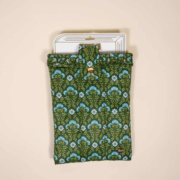 The Darling Effect's Everbloom Forest Green Book Cover features a green and blue floral pattern, folds with a button closure, and provides stylish book protection. It's shown on a light beige background with a white tag at the top.