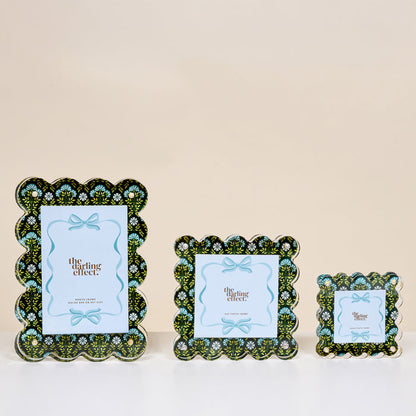 Three Everbloom Forest Green Rectangle Scalloped Acrylic Picture Frames by The Darling Effect, featuring a green, white, and blue floral pattern, are displayed against a beige background and arranged from largest to smallest.