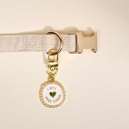 Add playful flair to your pet’s look with The Darling Effect Free Kisses Pawfect Collar Charm—a round beige charm featuring “I give free kisses” and a heart, perfect for accessorizing your pet’s collar.