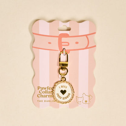 The Darling Effect’s Free Kisses Pawfect Collar Charm is a gold keychain with a round I give free kisses charm, on pink packaging with a drawn collar and cat—perfect for playful pet style and your pet collar charm collection.