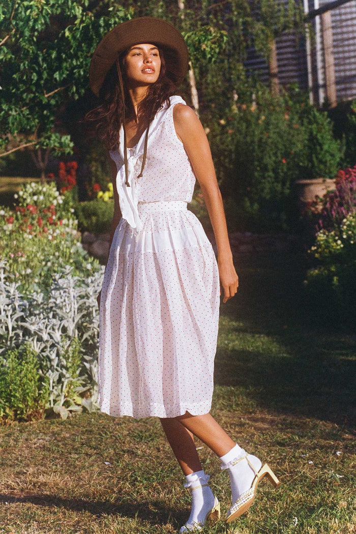 Model wearing a brown cotton bucket hat in a garden setting