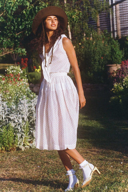 Model wearing a brown cotton bucket hat in a garden setting
