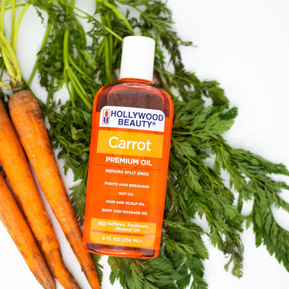 Hollywood Beauty Carrot Premium Oil 8oz / 236ml displayed with fresh carrots, a sulphate-, paraben- and mineral oil-free treatment for split ends, hair breakage, scalp care and body massage