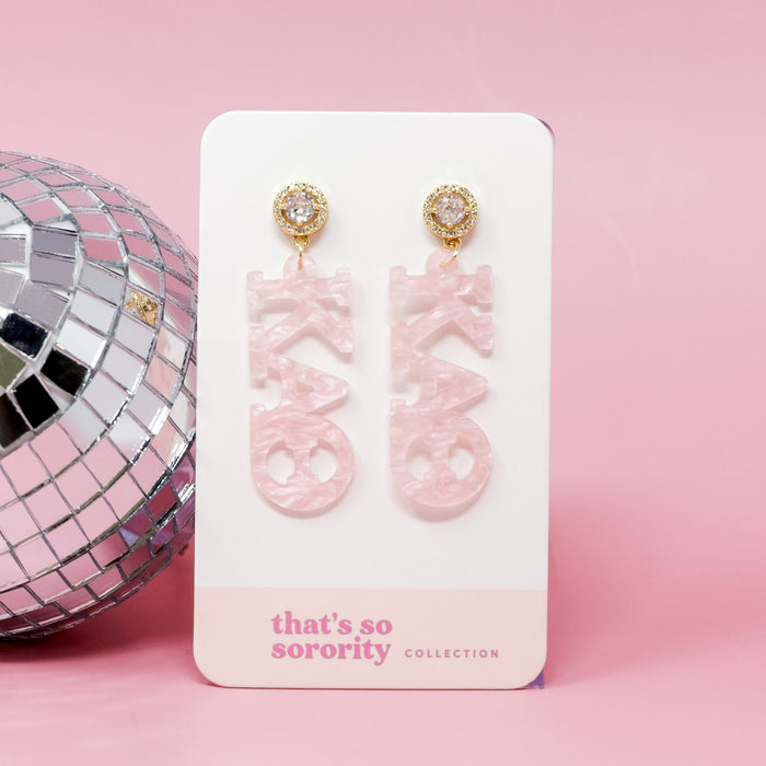 Two Kappa Alpha Theta Letter Pink Acrylic Earrings by The Darling Effect, featuring gold and rhinestone studs, displayed on a branded card—perfect for sisterhood events or adding sparkle to any bid-day basket.