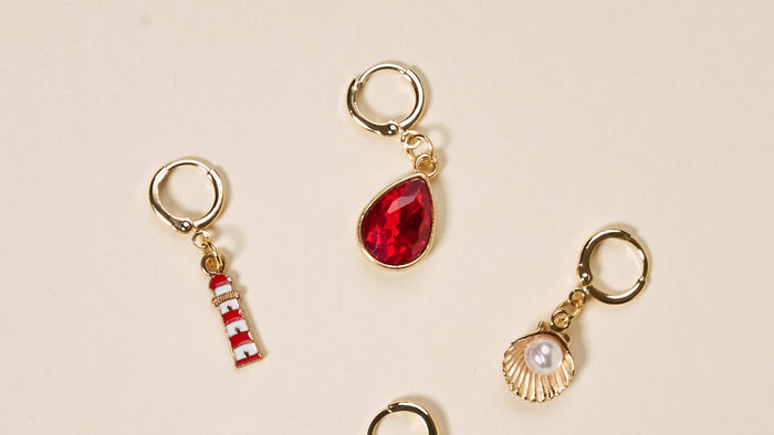The Darling Effect’s Lighthouse Glow The Ultimate Charm Pack includes four gold hoop charms: a red and white lighthouse, red teardrop gem, pearl seashell, and plain hoop—perfect for customizing Scrunchie Charm Sets or Make a Statement Necklaces.
