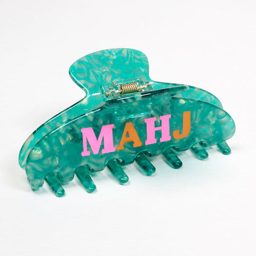 The Darling Effect's Mahj Word Up Claw Clip features a turquoise marble design with "MAHJ" in colorful letters, making it a playful way to add fun to any hairstyle. Shown here on a white surface.