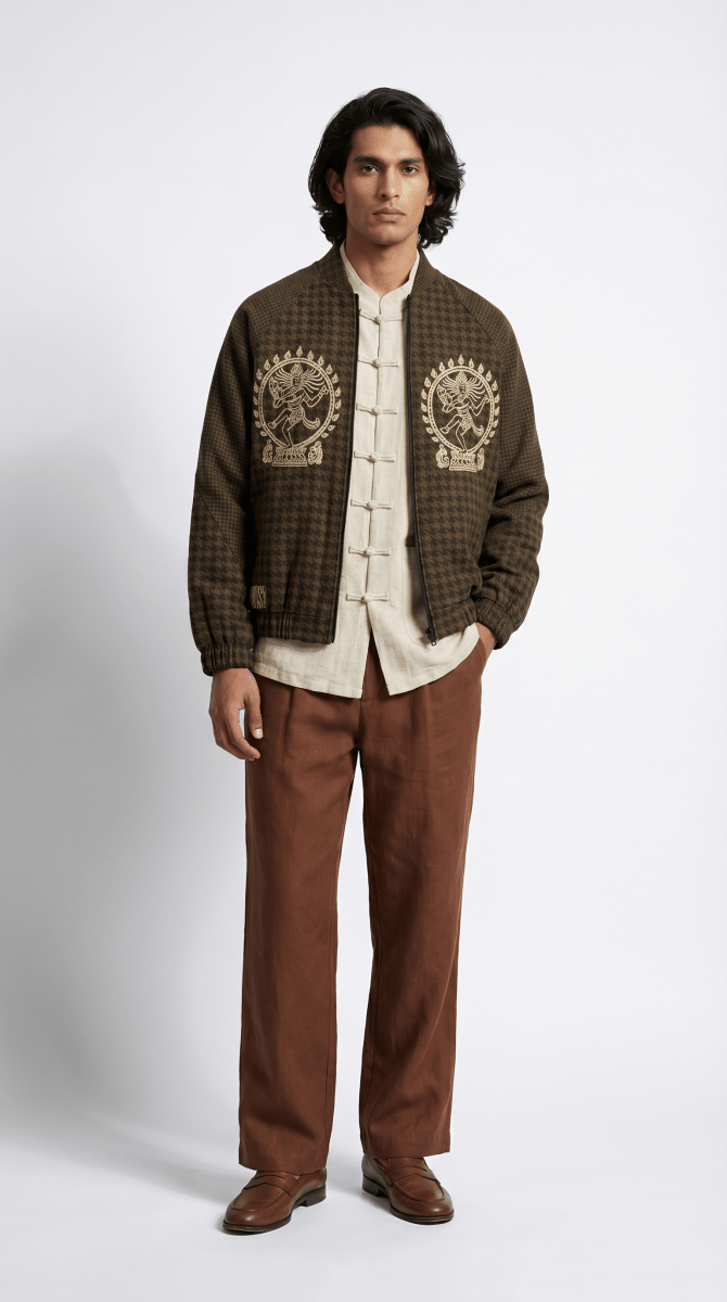 Man wearing the Natraj bomber-style jacket with a cream shirt and brown trousers, front view