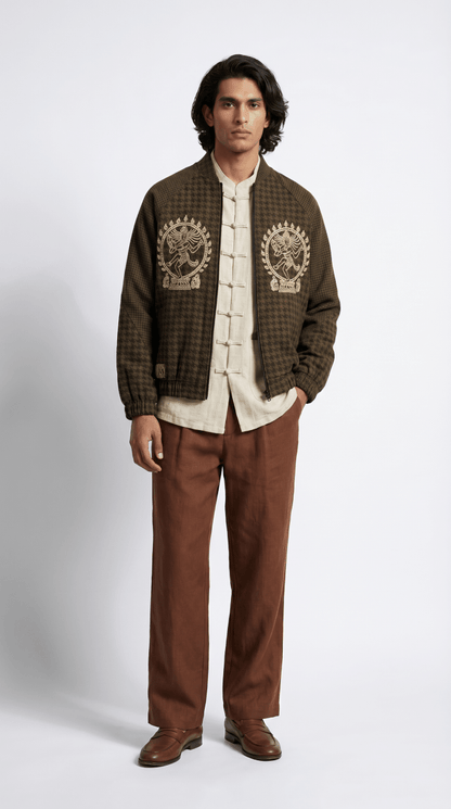 Man wearing the Natraj bomber-style jacket with a cream shirt and brown trousers, front view