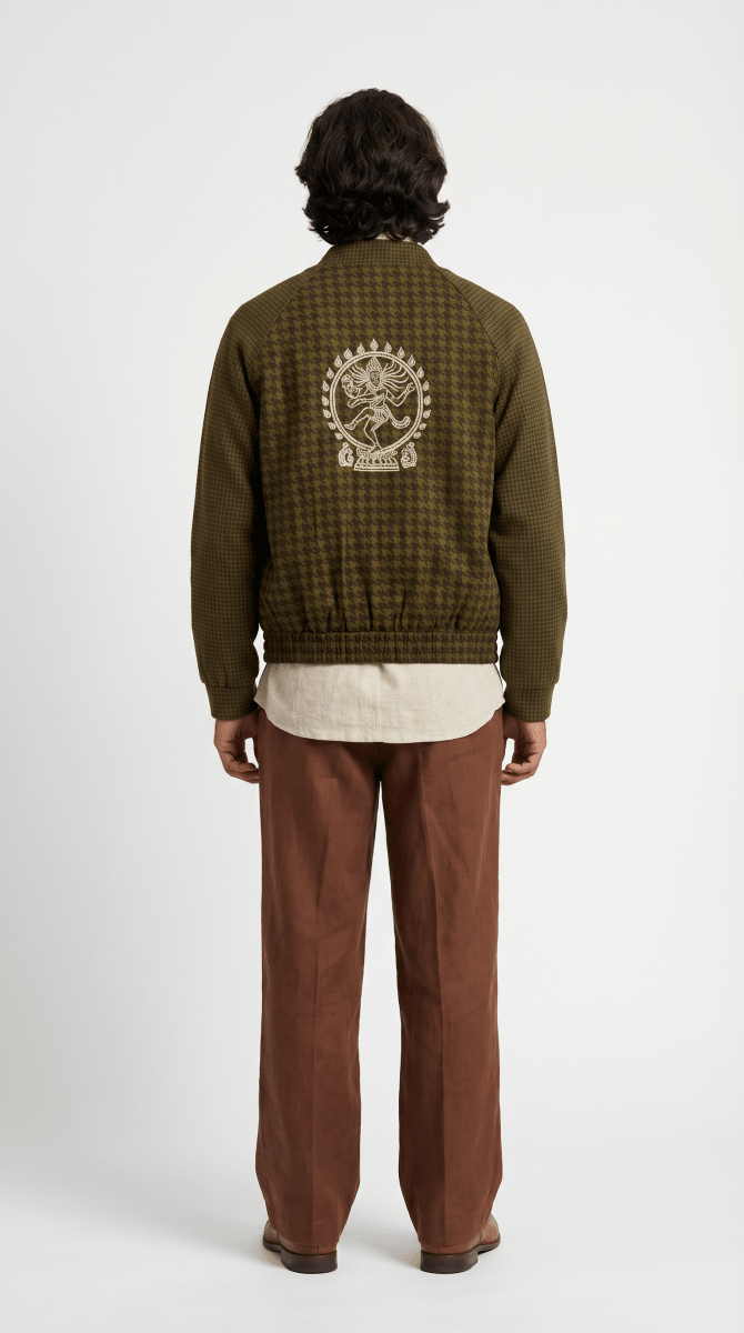 Man wearing the Natraj bomber-style jacket with brown trousers, back view, with a cream Nataraja figure