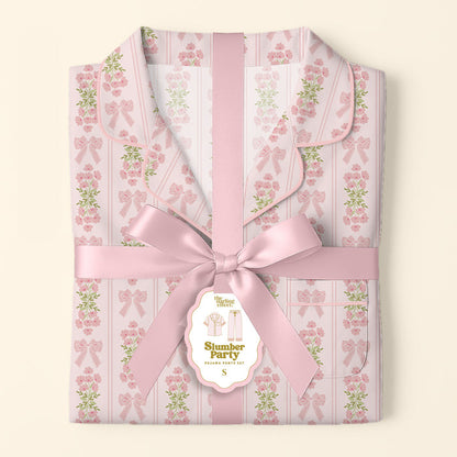 The Darling Effect's Oh So Fancy Pink Slumber Party Pajama Pants Set, featuring pink floral and bow patterns in ultra-soft fabric, arrives wrapped with a wide satin ribbon and decorative tag—an ideal cozy gift set.