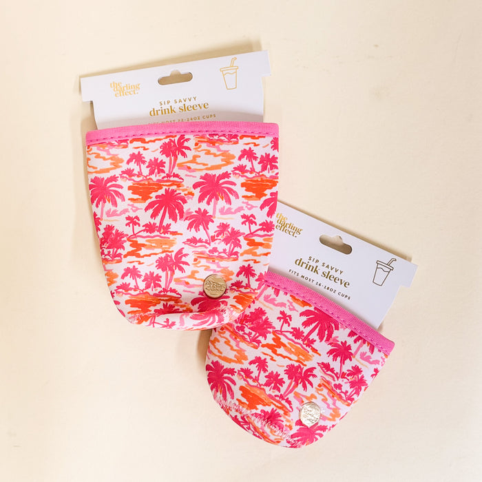 Two Paradise Palms Sip Savvy Drink Sleeves by the-darling-effect, featuring pink and orange tropical palm prints, are shown packaged for mini party cups on a light surface.