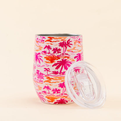 The Darling Effect Paradise Palms Wine Tumbler features a pink and orange palm tree print, triple-wall insulation, and includes a clear spill-resistant lid.