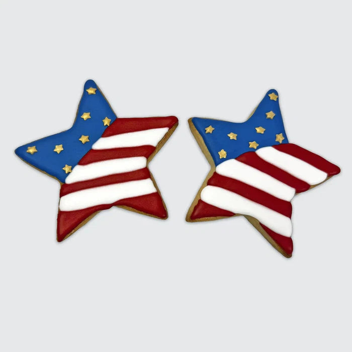 Two star-shaped cookies decorated like the American flag with red and white stripes and blue sections filled with gold stars.
