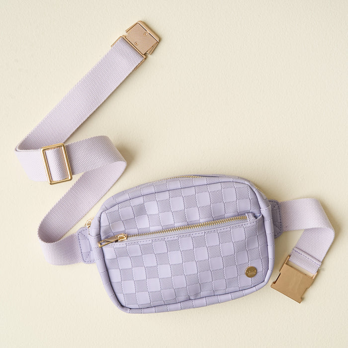The Darling Effect's Periwinkle Urban Check Belt Bag features light purple checkered vegan leather, a gold zipper, and an adjustable strap, shown against a pale yellow background.