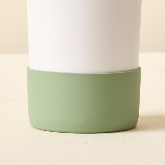 Close-up of the bottom half of a white tumbler with The Darling Effect Sage Tumbler Silicone Boot, offering a stylish, no-slip grip.