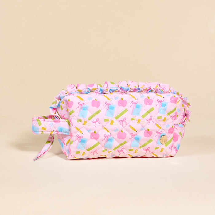 The Darling Effect School's In Session Essentials Quilted Cosmetic Pouch is a pastel pink bag with a handle and ruffle trim, featuring cute bow, trophy, heart, perfume bottle, and lipstick designs—ideal for holding your makeup on the go.