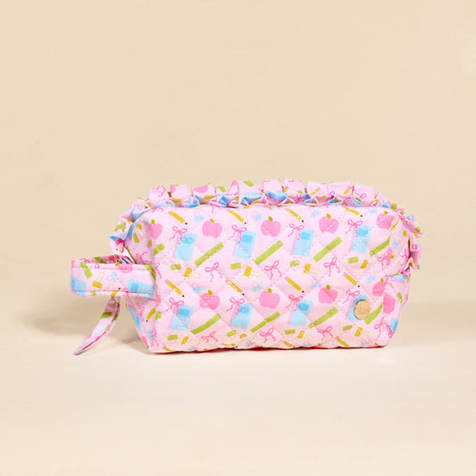 The Darling Effect School's In Session Essentials Quilted Cosmetic Pouch is a pastel pink bag with a handle and ruffle trim, featuring cute bow, trophy, heart, perfume bottle, and lipstick designs—ideal for holding your makeup on the go.